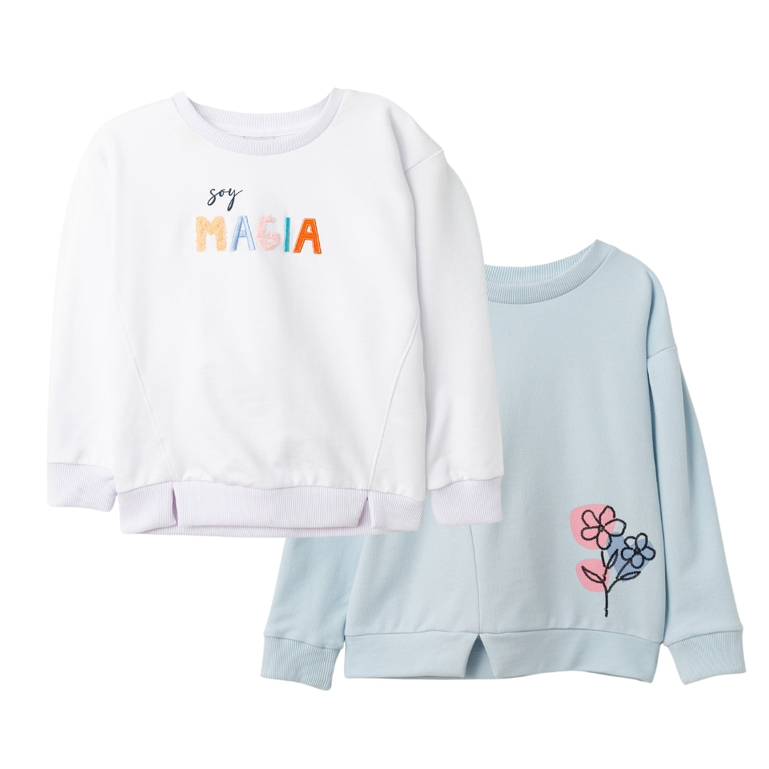Zwei Mädchen-Pullover im Set – einer mit Paillettenblume, der andere mit 'Soy magia' Stickerei.