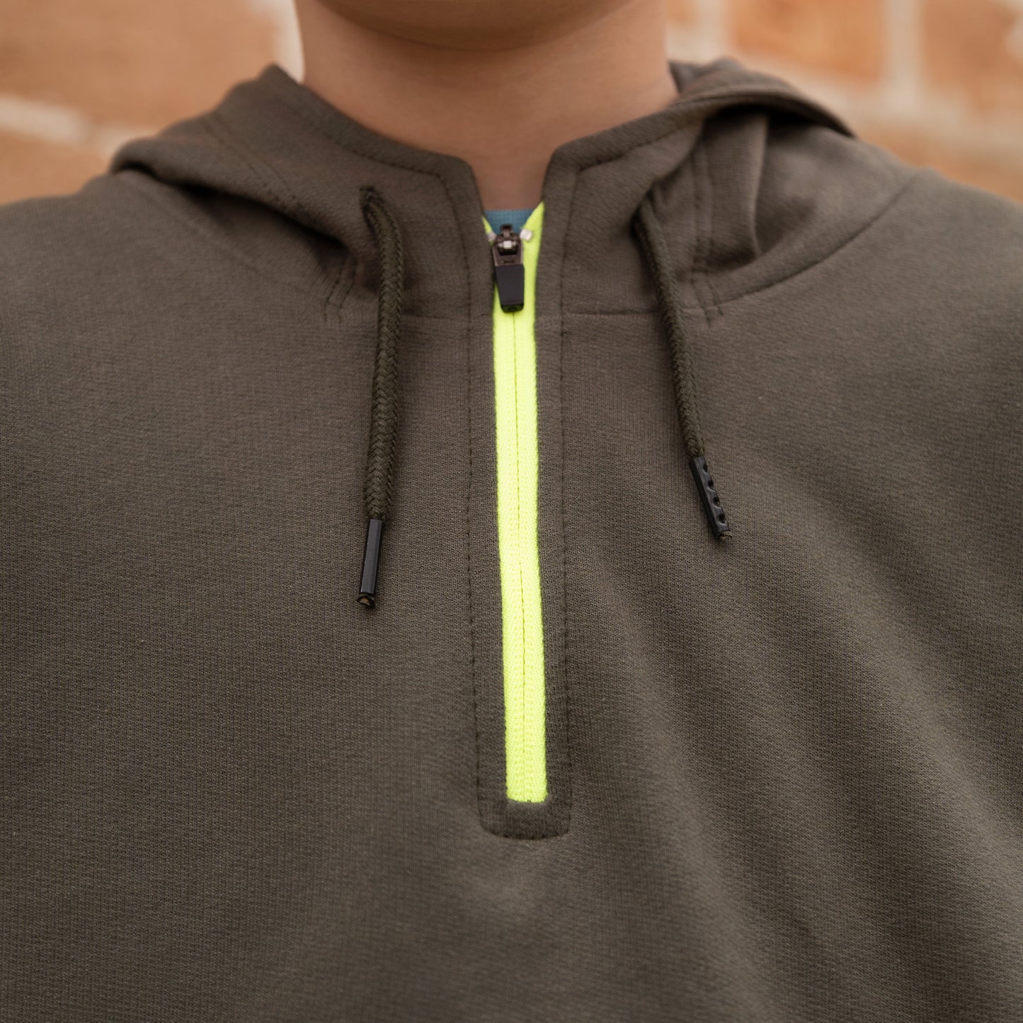 ahaufnahme des neonfarbenen Reißverschlusses des Abenteuer Hoodies