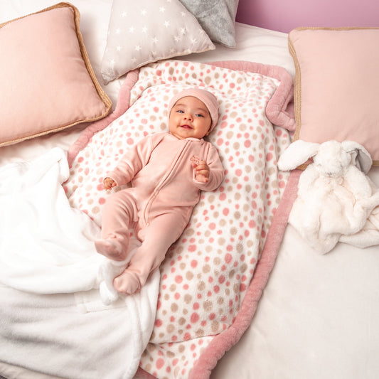 Baby-Mädchen trägt das rosa Baby Set mit Zip-up Strampler, Body mit Katzen-Motiv, Mütze und Socken – Frontansicht.