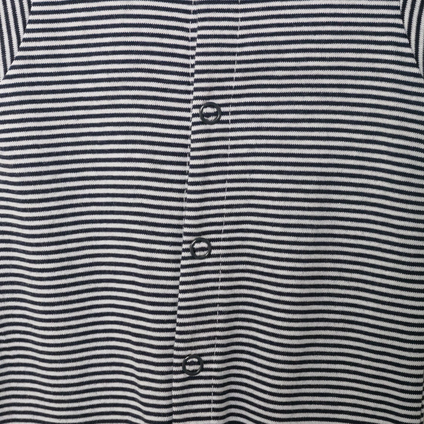 Nahaufnahme des Stoffes und der Details des blau-weiß gestreiften Baby-Schlafanzugs.