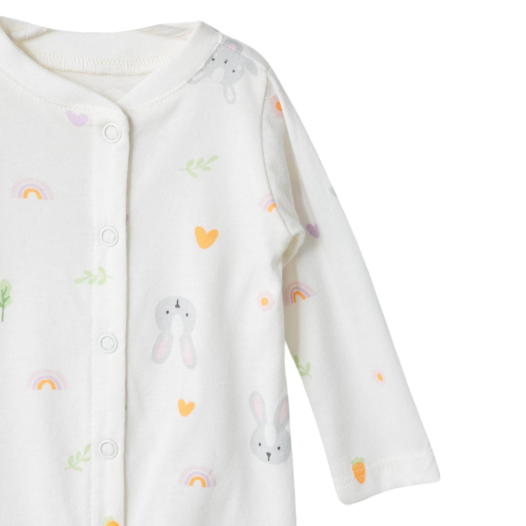 Nahaufnahme des weißen Baby-Stramplers mit Häschen, Karotten und Regenbögen aus 100% Baumwolle.