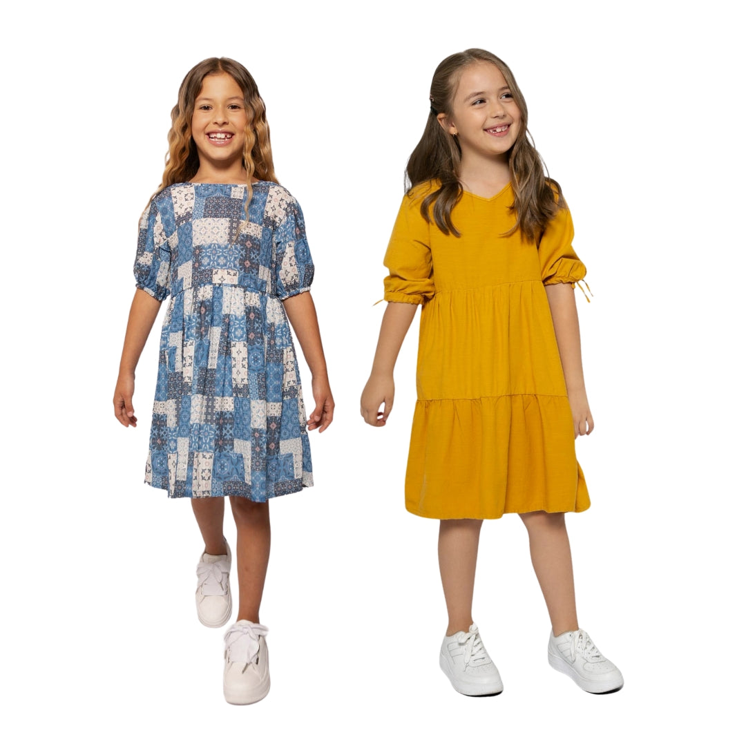 Zwei Mädchen in eleganten Kleidern – Senf und Blau, spielen zusammen