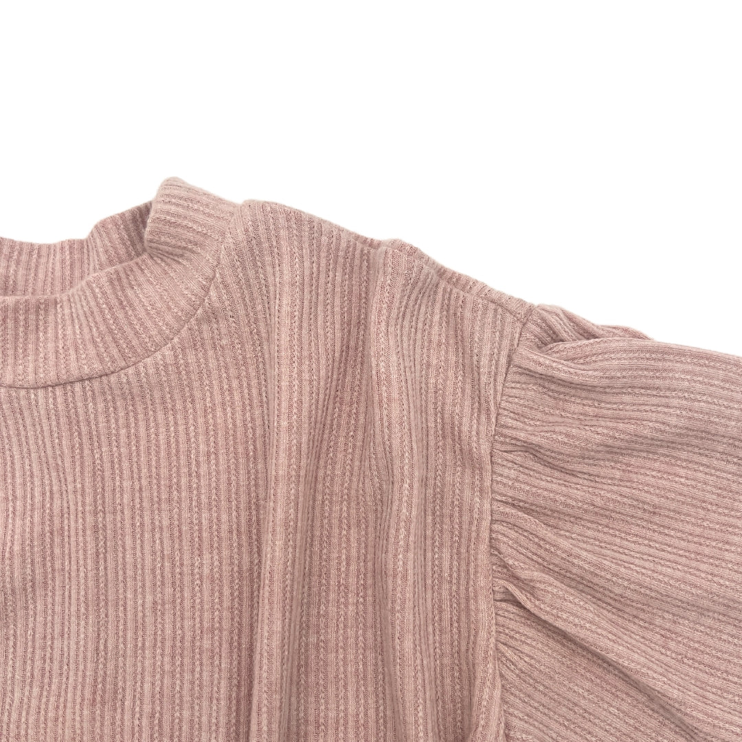 Nahaufnahme des Blush Pink Pullovers, das den lässigen Schnitt und die Textur zeigt.
