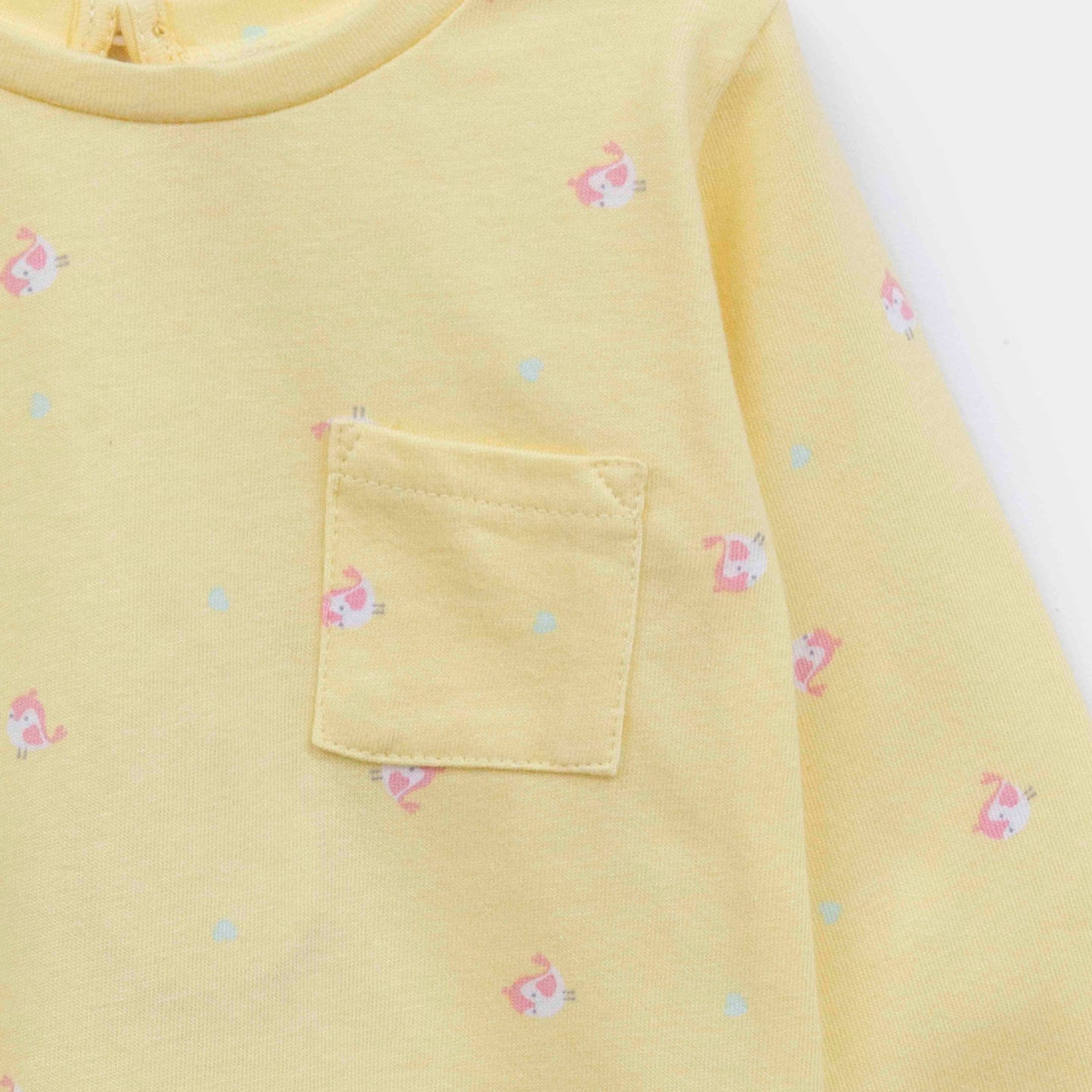 Detailansicht der kleinen Brusttasche und des Vögelchen-Prints auf dem Baby T-Shirt