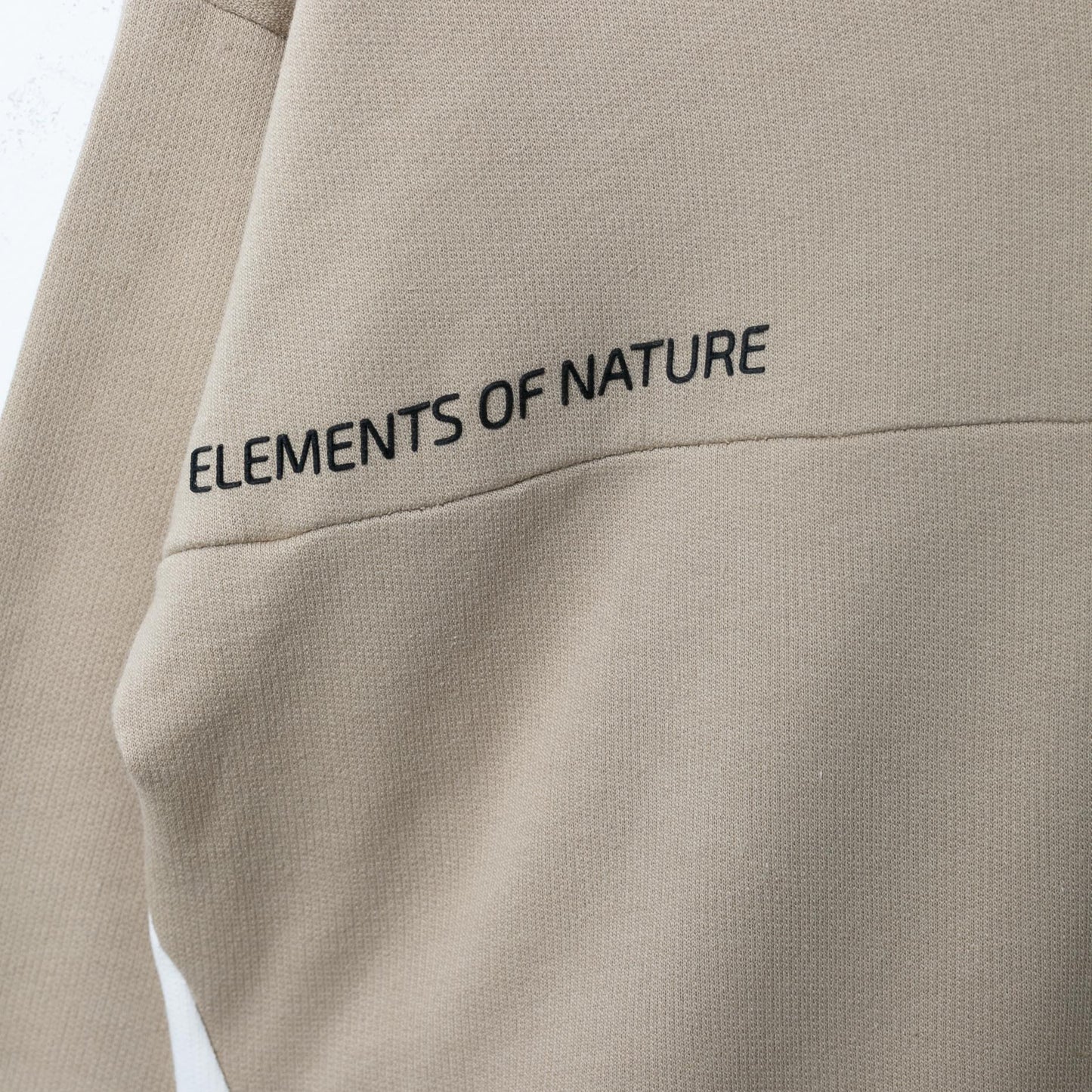 Nahaufnahme des Drucks auf dem elfenbeinfarbenen Hoodie