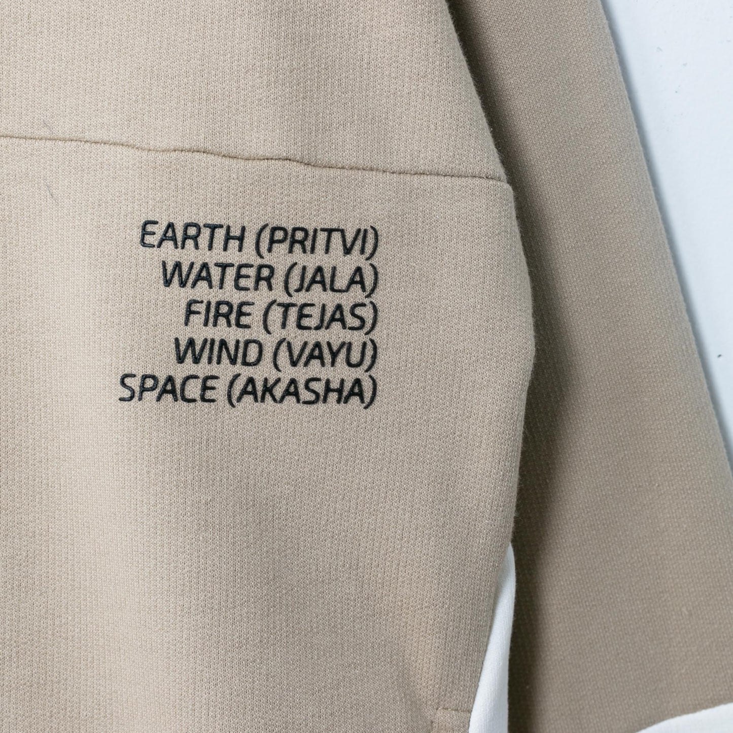 Nahaufnahme der elfenbeinfarbenen Einsätze und versteckten Taschen des Hoodies