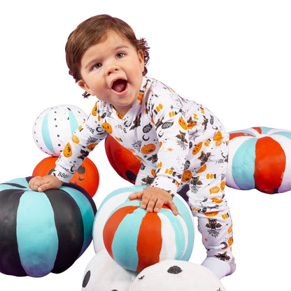 Kind trägt Unisex-Halloween-Babypyjama mit fröhlichem Kürbismuster beim Spielen, weiche und hautfreundliche Baumwolle