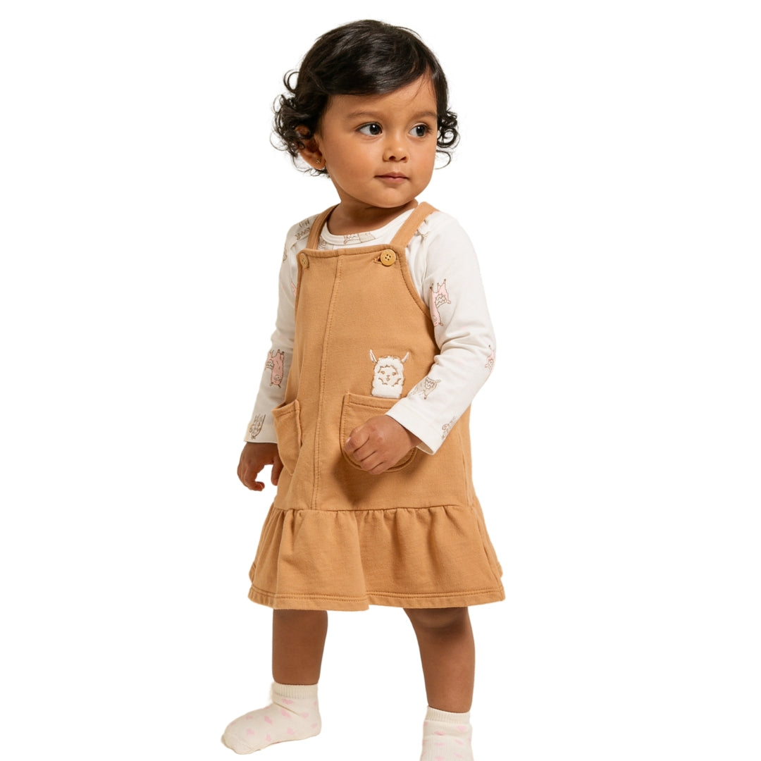 Kleines Mädchen trägt das Llama-Latzkleid Set mit Langarm-Body und braunem Kleid
