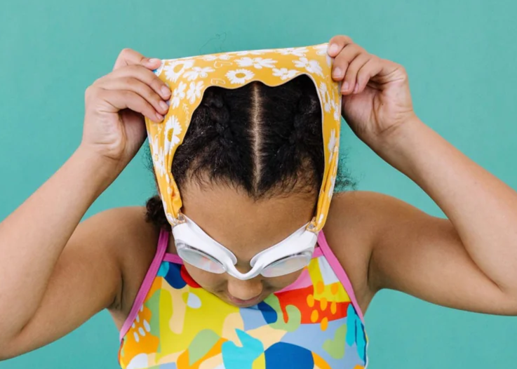 Mädchen setzt sich Schwimmbrille auf – kindgerecht, bequem und ziepfrei