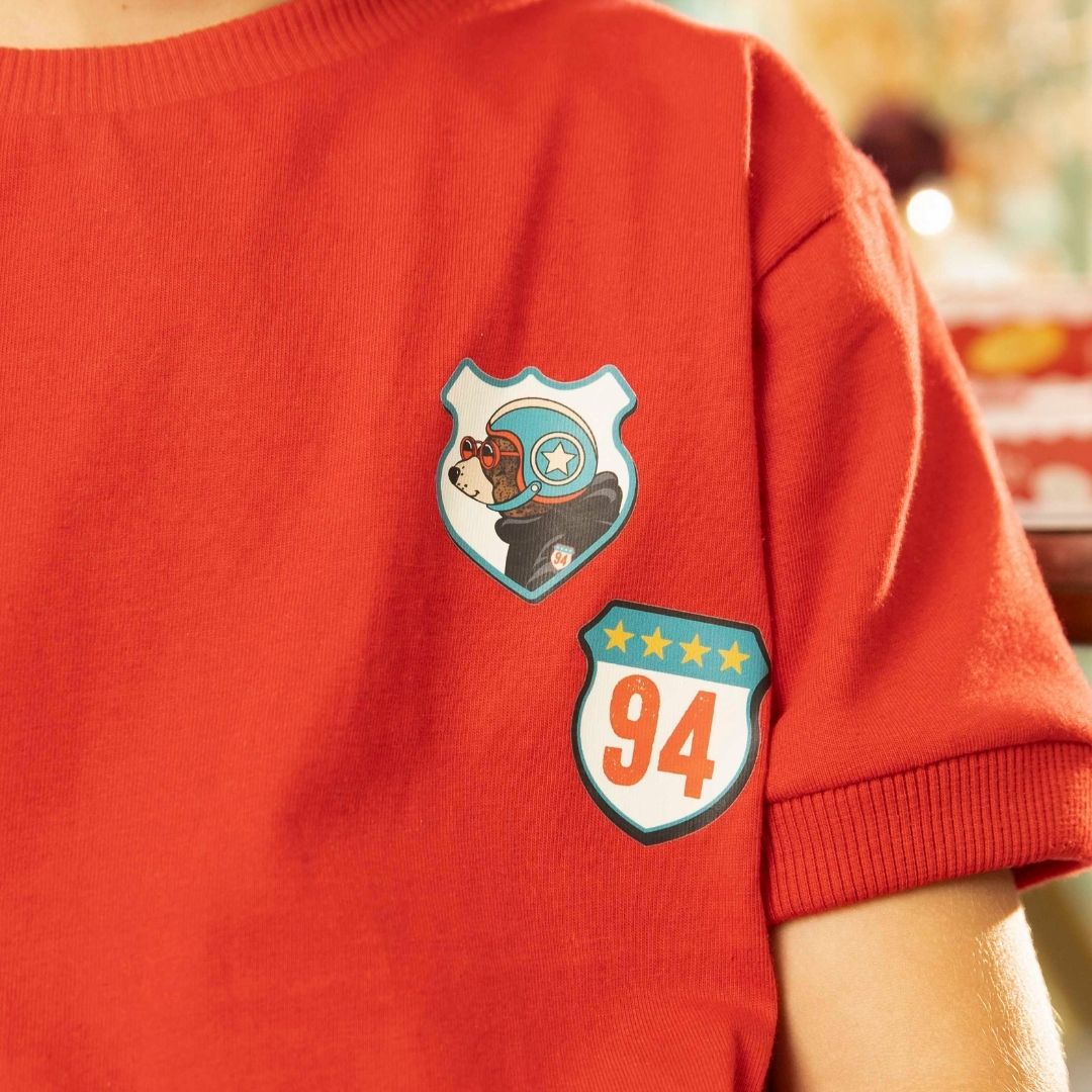 Detailaufnahme des Roller-Bär-Prints auf rotem Kinder-T-Shirt – weiche Baumwolle, hochwertige Verarbeitung.
