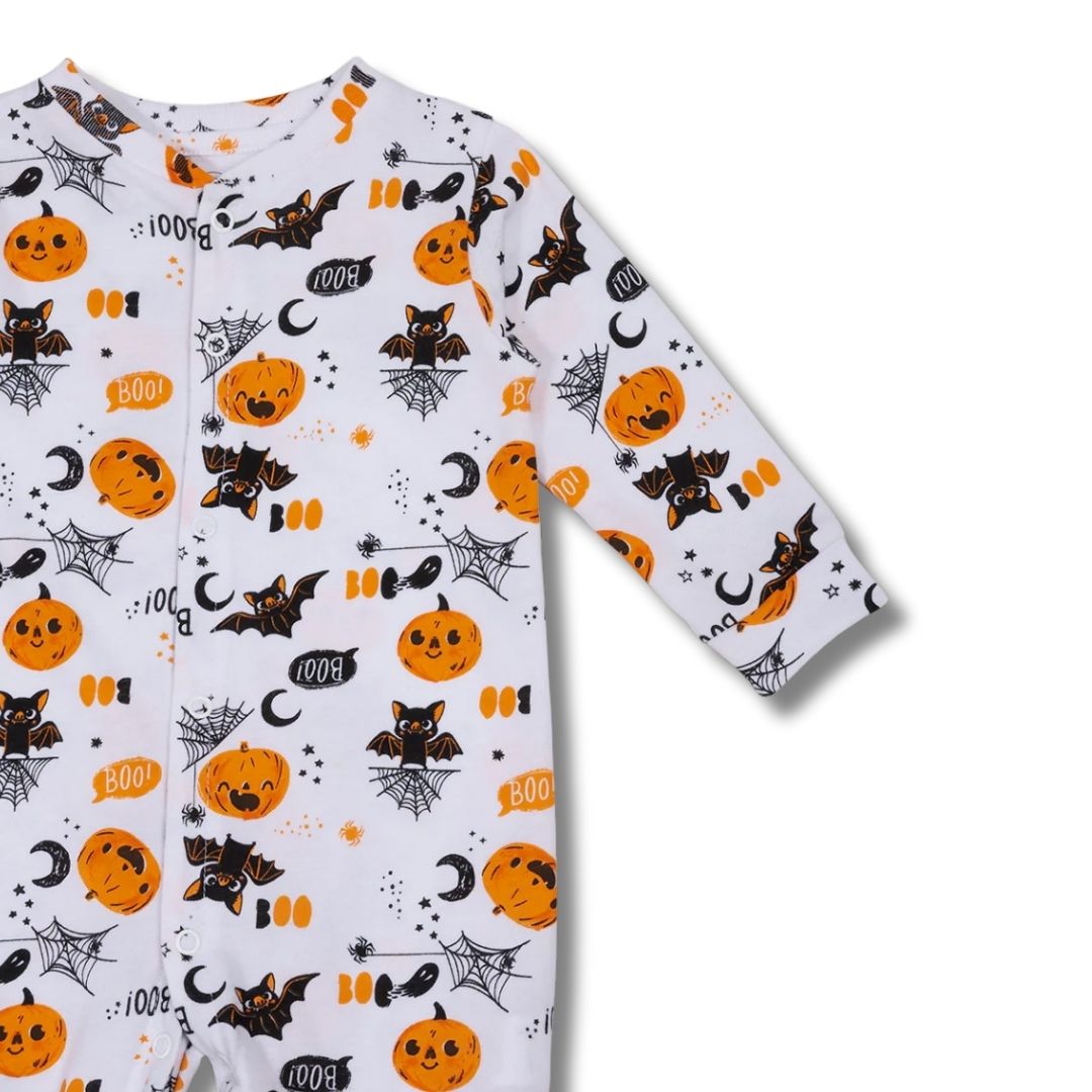 Nahaufnahme des Unisex-Babypyjamas mit fröhlichem Kürbismuster auf weißer Baumwolle