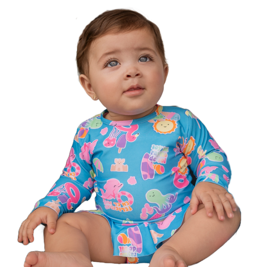 Fröhliches Baby sitzt lachend im blauen Badeanzug mit Volant, bereit für den Sommer.