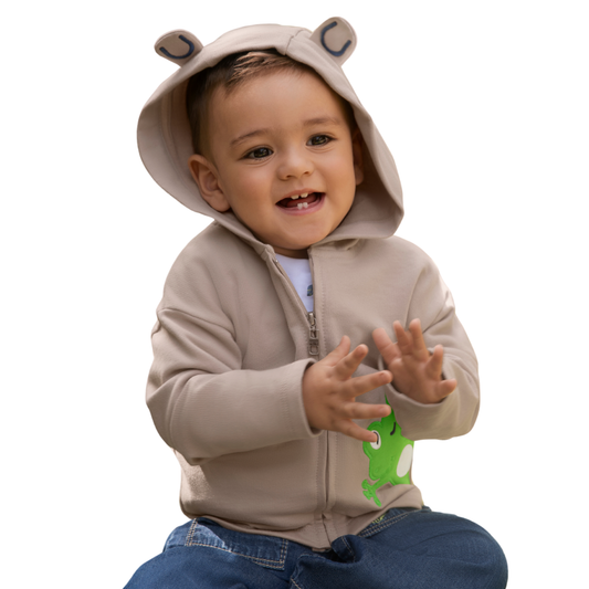 Glückliches Kind trägt den Froschfreude Hoodie in Sand – bereit für Abenteuer und Entdeckungen.