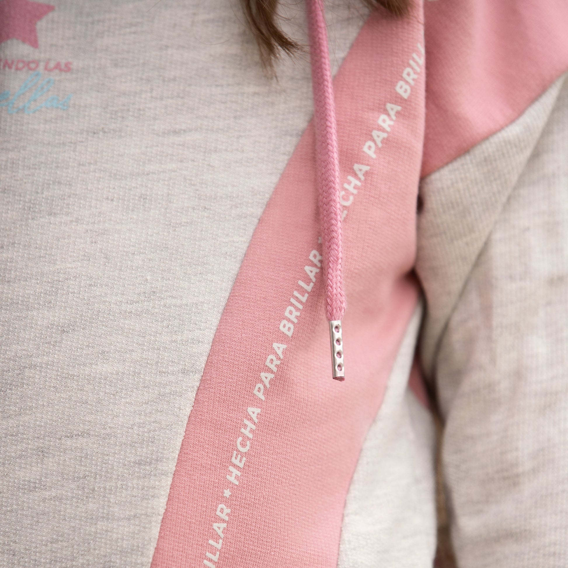 Detailaufnahme des Spruchs „Hecha para brillar“ auf dem Pastelltraum Hoodie.