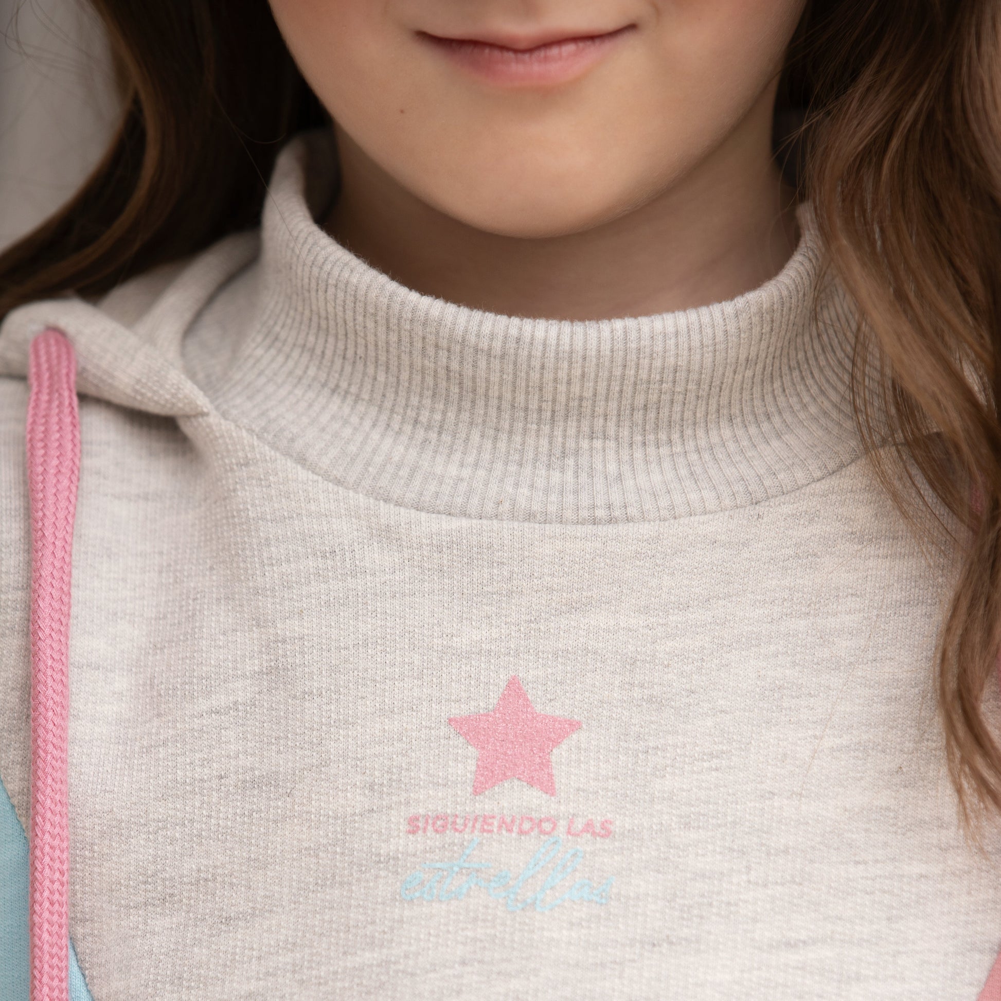 Detailaufnahme des pinken Sterns und des Kragens des Pastelltraum Hoodies.
