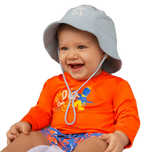 Fröhliches Baby im blauen Badeoutfit mit Oktopus-Print – trägt Badehose und passendes Shirt, bereit für Wasserspaß
