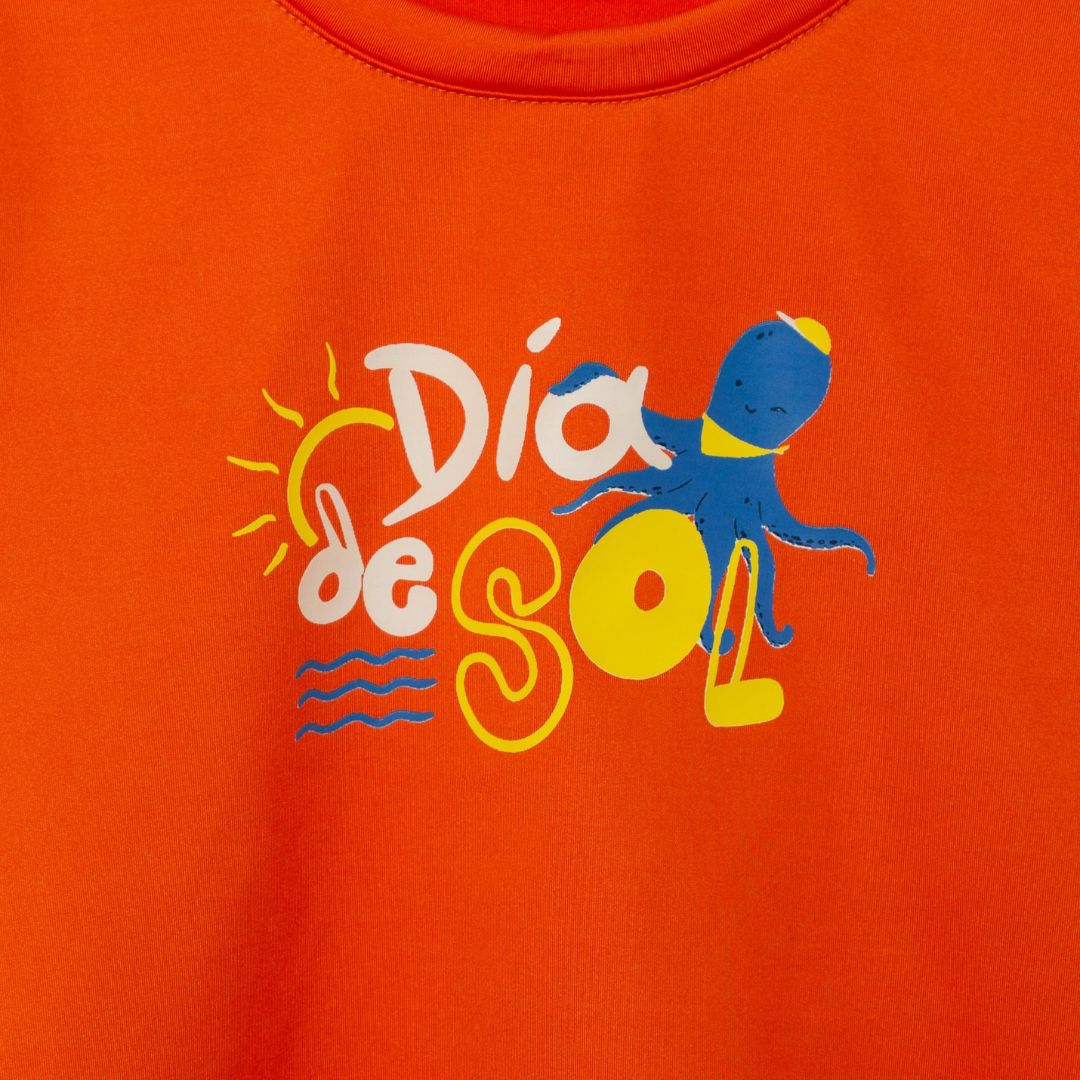 Detailansicht des Prints auf dem orangefarbenen Baby-Badeshirt