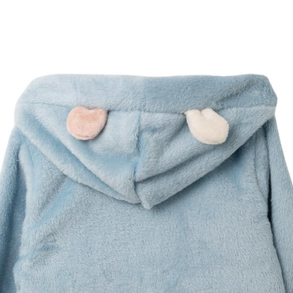 Nahaufnahme der süßen Ohrenapplikationen und der praktischen Taschen der hellblauen Plüschjacke für Mädchen.