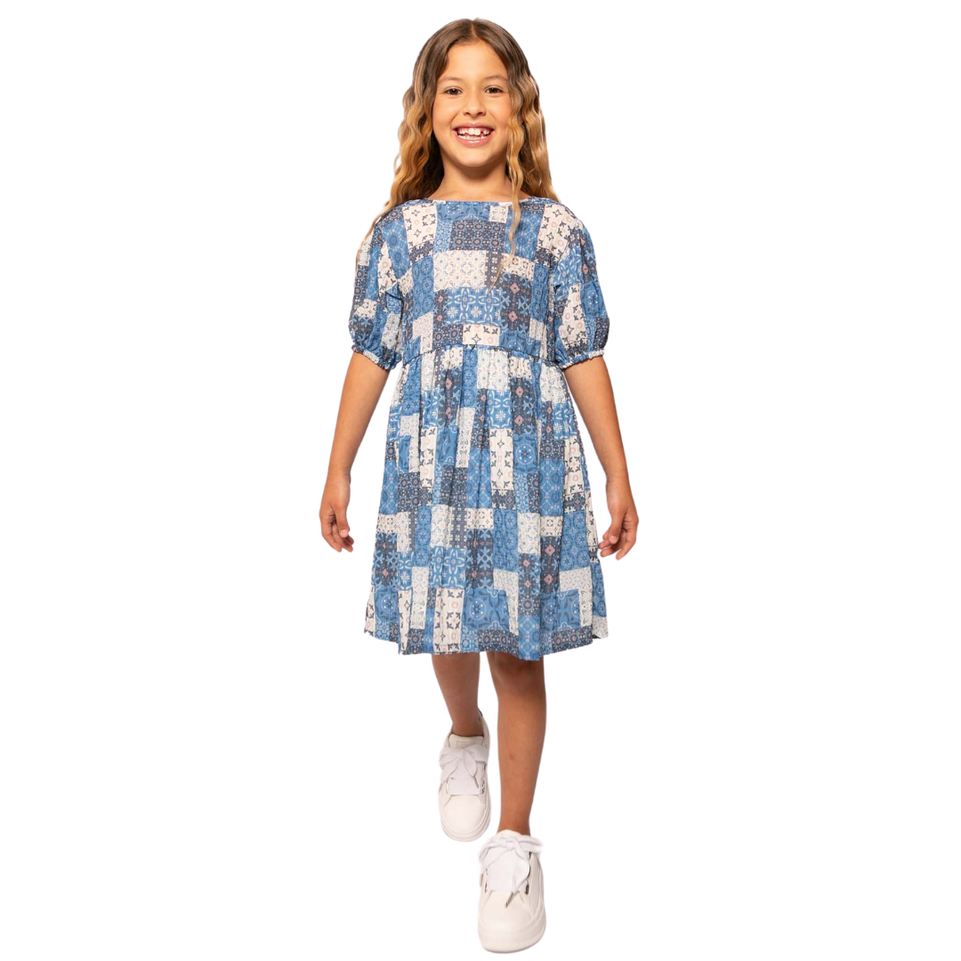 Mädchen trägt elegantes blaues Kleid mit Mosaikmuster und gerafften Ärmel-Details