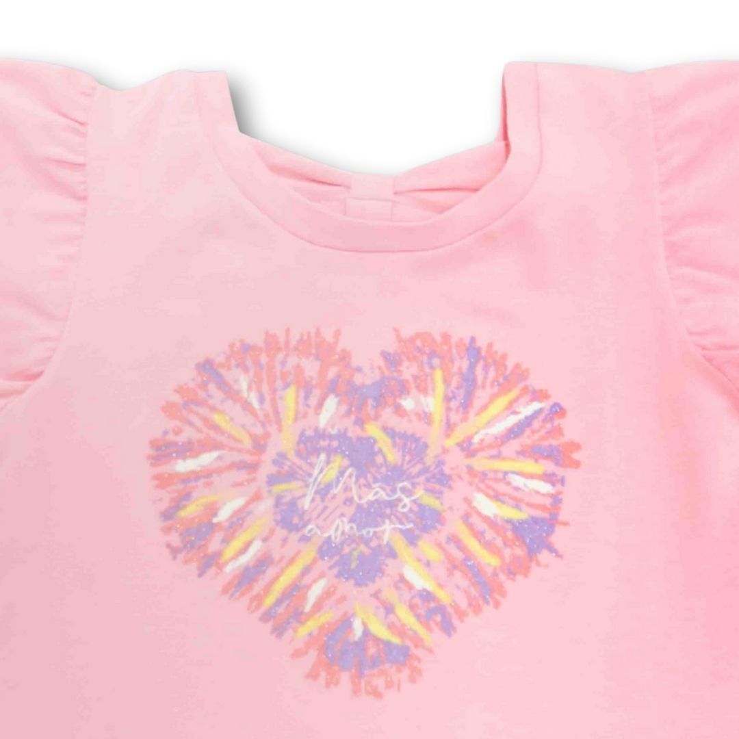 Nahaufnahme der zarten Schleifenöffnung am Rücken und des Herz-Prints auf dem T-Shirt.