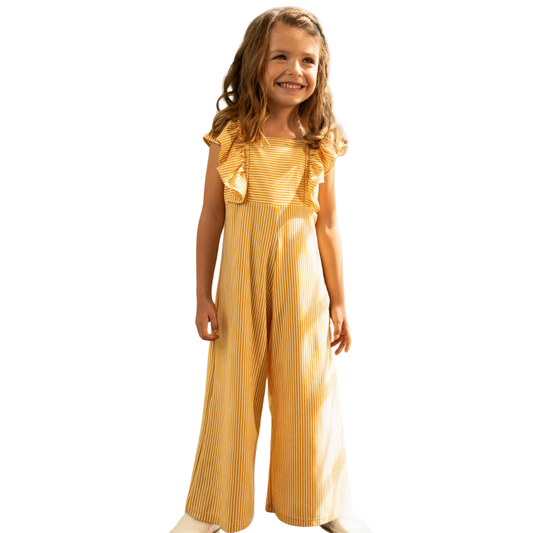 Fröhliches Mädchen im gelb-weiß gestreiften Jumpsuit mit kurzen Ärmeln – ideal für warme Tage und spielerische Abenteuer.