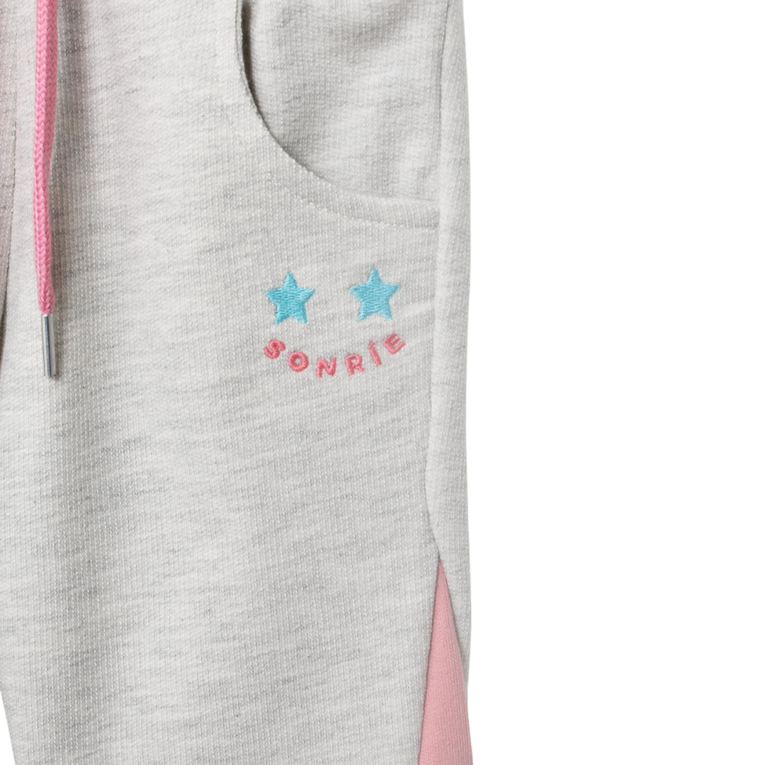 Nahaufnahme der „Sonríe“-Stickerei auf dem Oberschenkel des Joggers