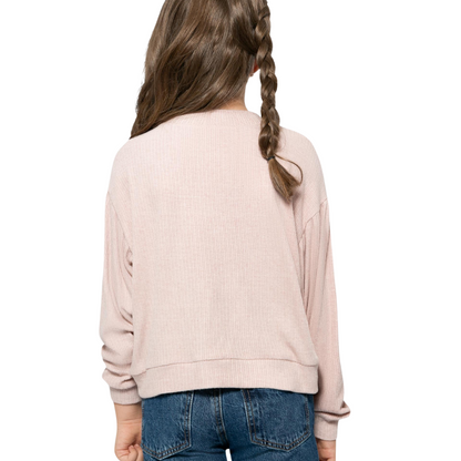 Mädchen trägt den Blush Pink Pullover von hinten, mit sauberem Schnitt und bequemen, gerippten Bündchen